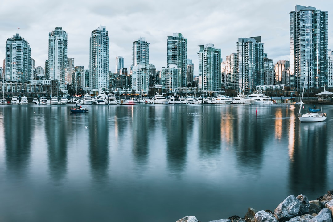 high rise buildings reflected on water during daytime