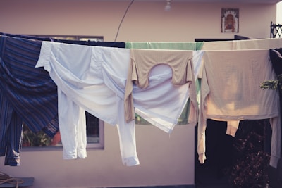 Freshly washed clothes hanging on a drying rack outdoors.