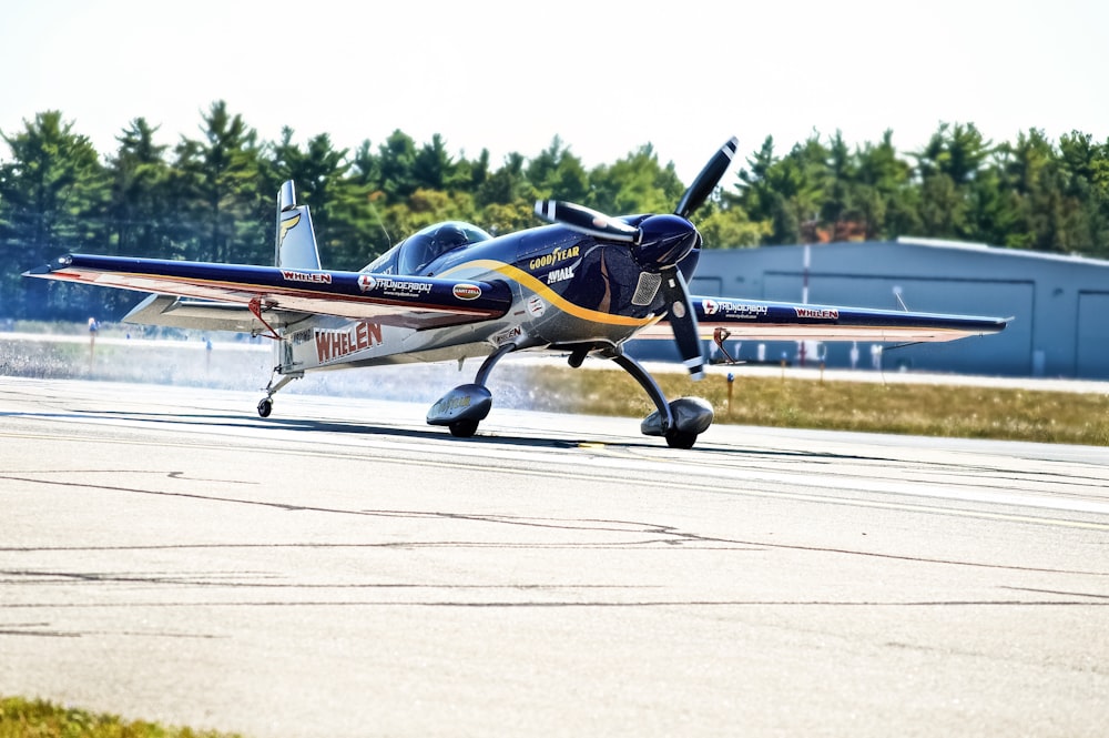 blue and gray aircraft on concrete pavement during daytime