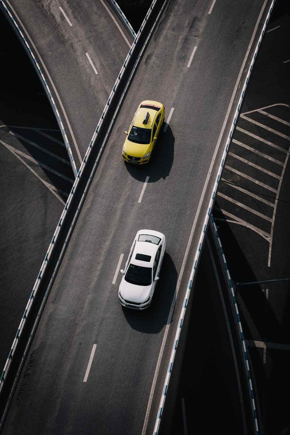 yellow and white vehicles passing on black asphalt road