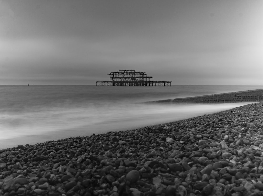 grayscale photography of structure on body of water during daytime