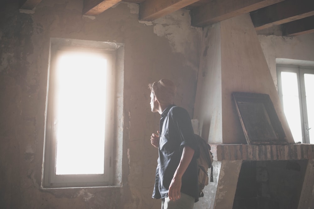 man wearing brown hat looking on window