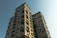 Two residential high-rise buildings with multiple balconies and windows. The structures exhibit a modern architectural style with a light-colored exterior.