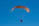 A happy customer standing next to his light sport powered parachute covered by vientoguard's protective cover on a sunny day.