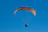 A happy customer standing next to his light sport powered parachute covered by vientoguard's protective cover on a sunny day.