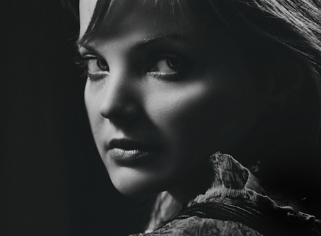 Black and white portrait of a person with expressive eyes, captured by Silva Porto.