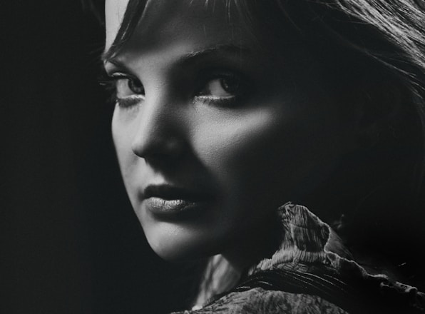 A striking black-and-white portrait showcasing dramatic lighting and intense emotion.