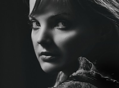 A striking black and white portrait capturing raw emotion against a charcoal grey backdrop.