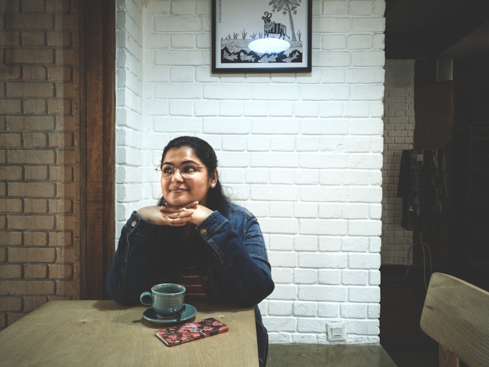 smirking woman sitting beside table inside room