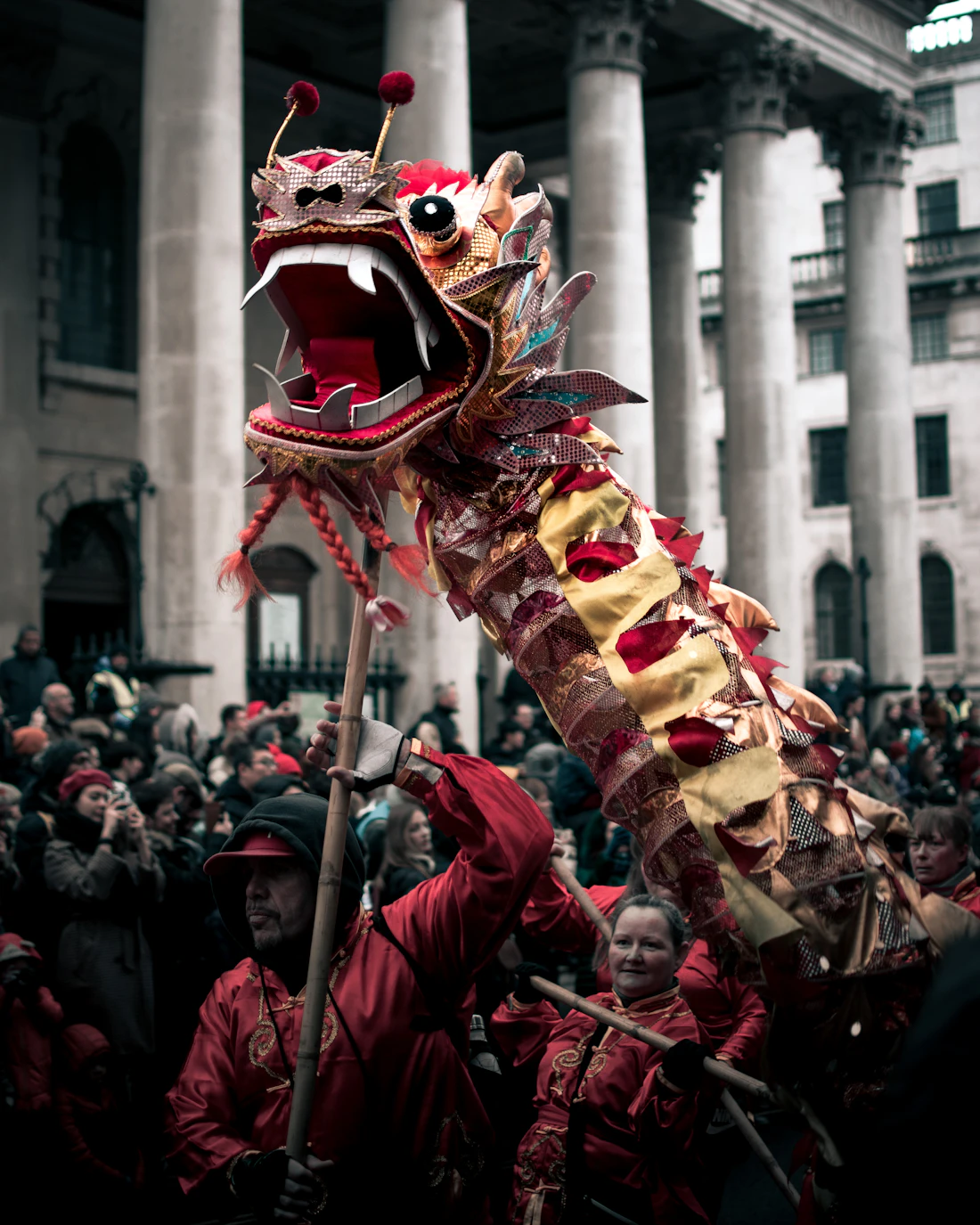 Lion dance mid-leap in the street, crowd pressing in