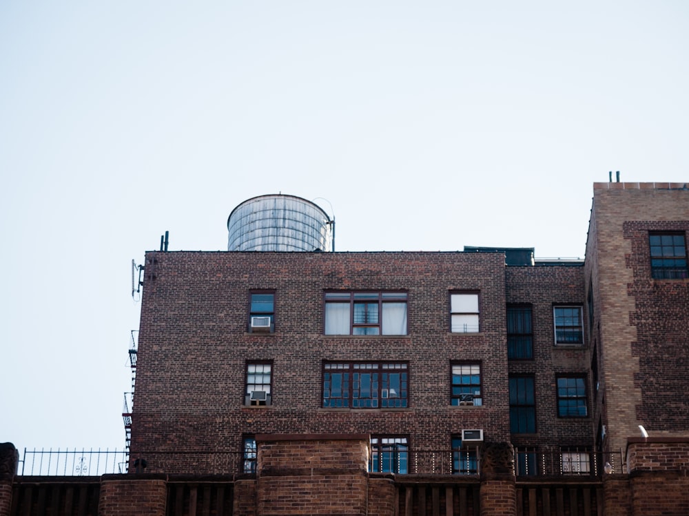 brown brick building with tall water tank behind