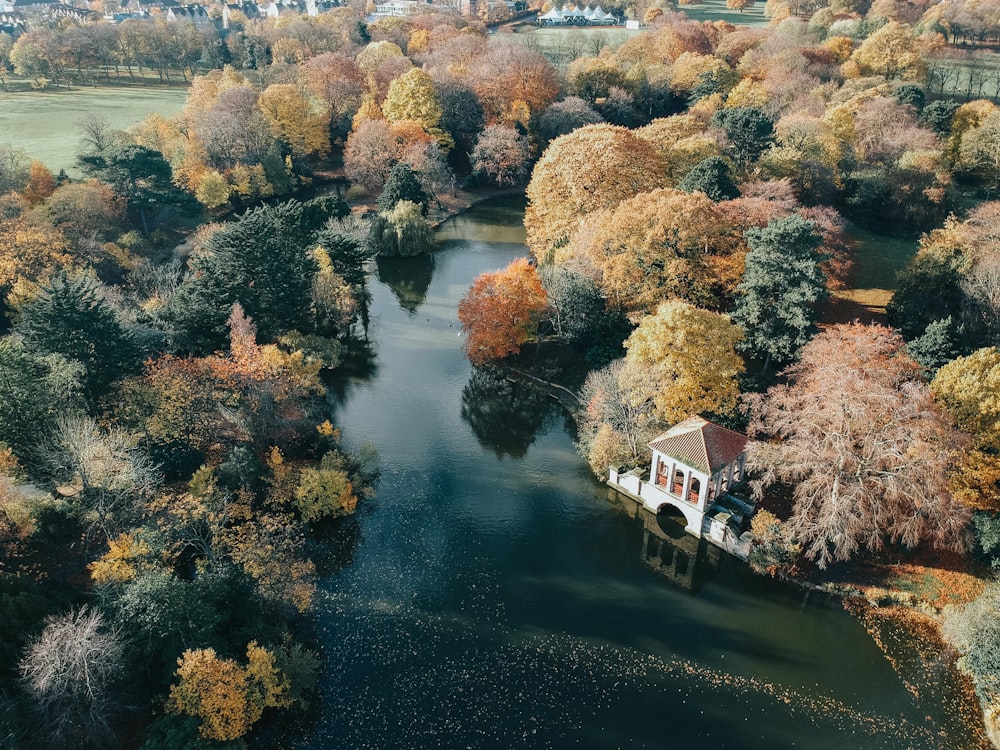 white and brown house beside body of water and trees