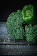 Close-up of fresh cucumbers and spicy peppers on a rustic wooden table