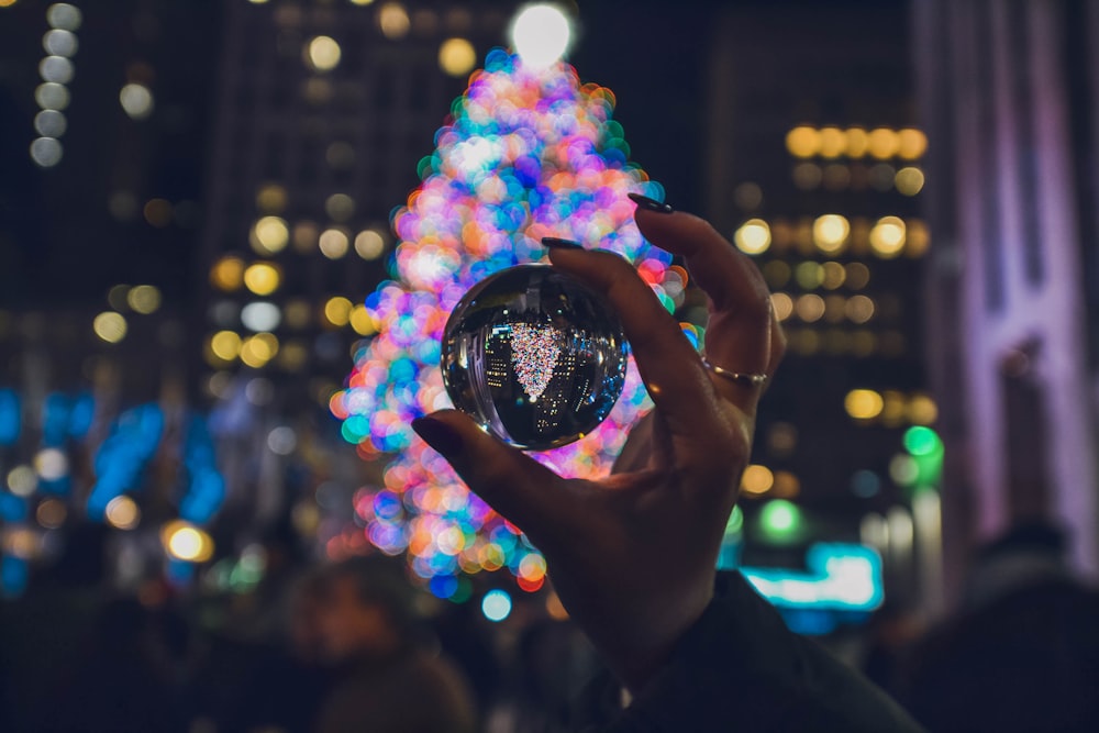 person holding clear glass ball