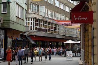 Street view of a commercial area with shops and pedestrian traffic.