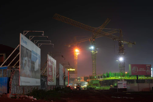 Night shot of a construction site illuminated by soft lights, highlighting ongoing work.