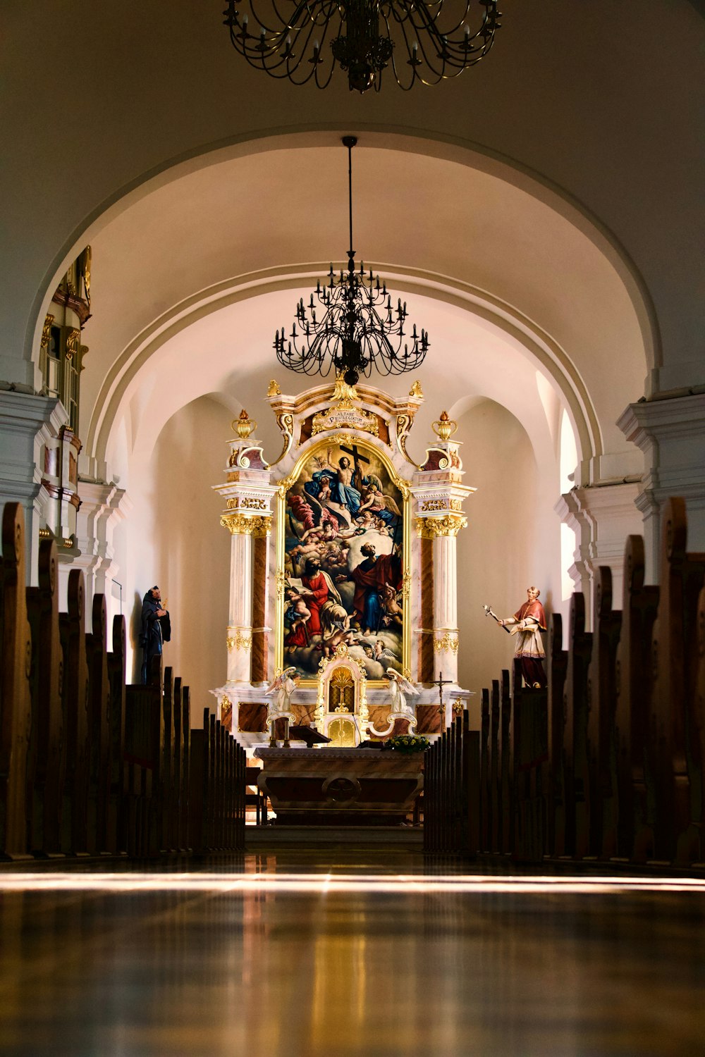 chandelier and pew chairs inside facing altar inside church