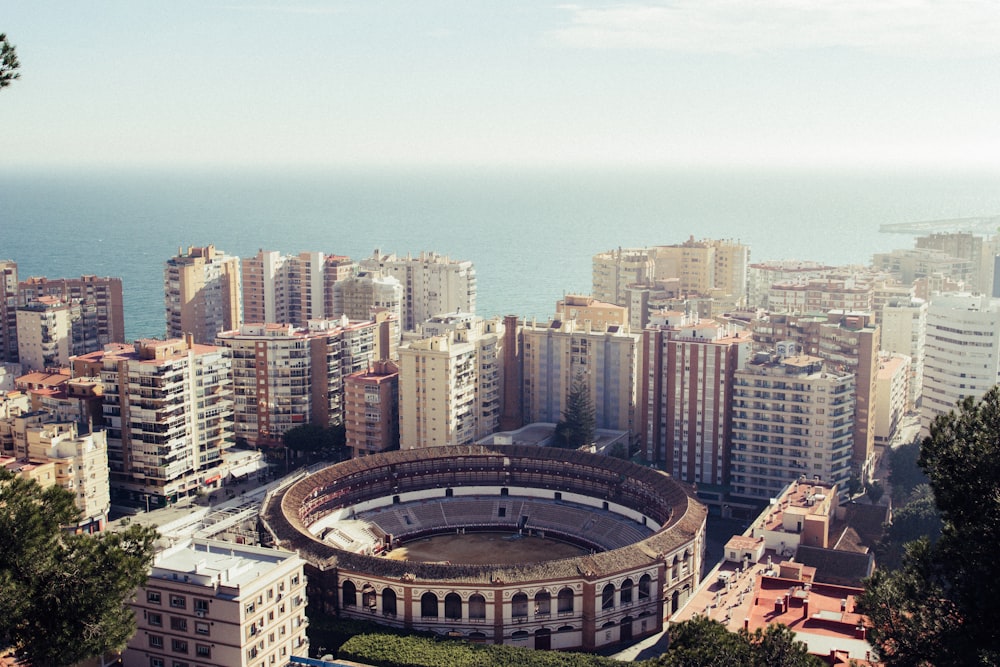 round stadium surrounded by buildings near the sea