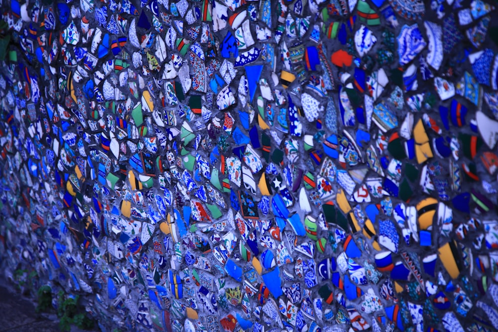 a wall covered in lots of different colored glass bottles