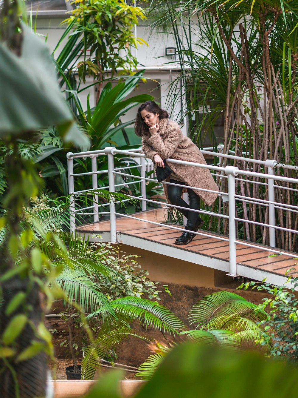 Femme appuyée sur un pont de garde-corps en métal blanc