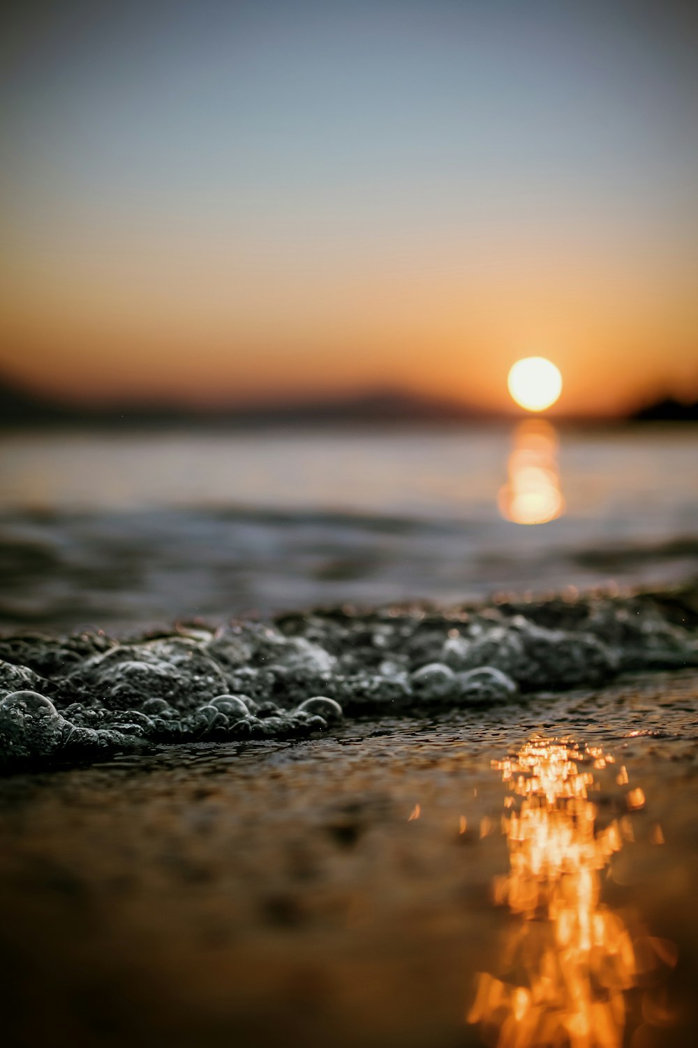 bokeh photography of splash of wave on seashore