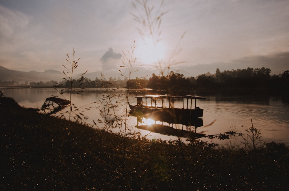 Silhouette eines Bootes auf dem Wasser während der goldenen Stunde
