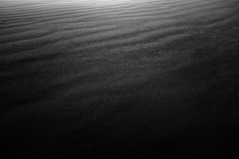 a black and white photo of a sand dune