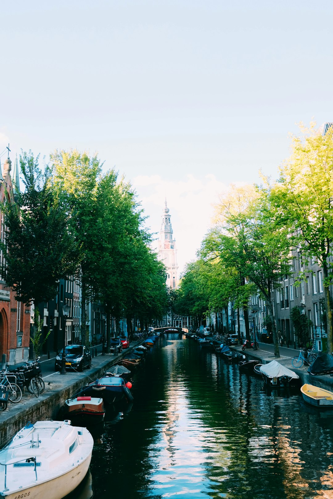 white and black boats on calm body of water between roads