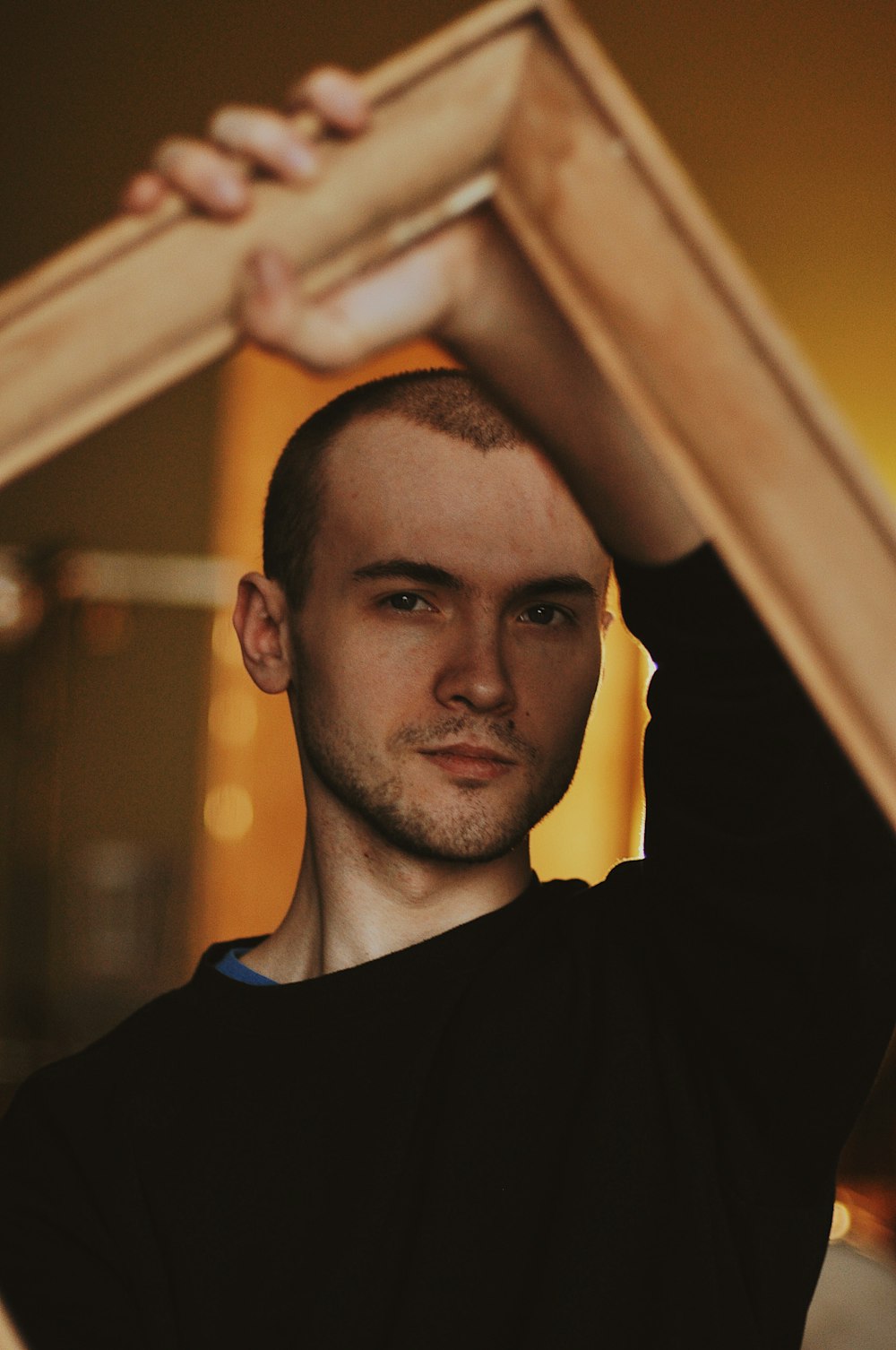 man holding wooden frame