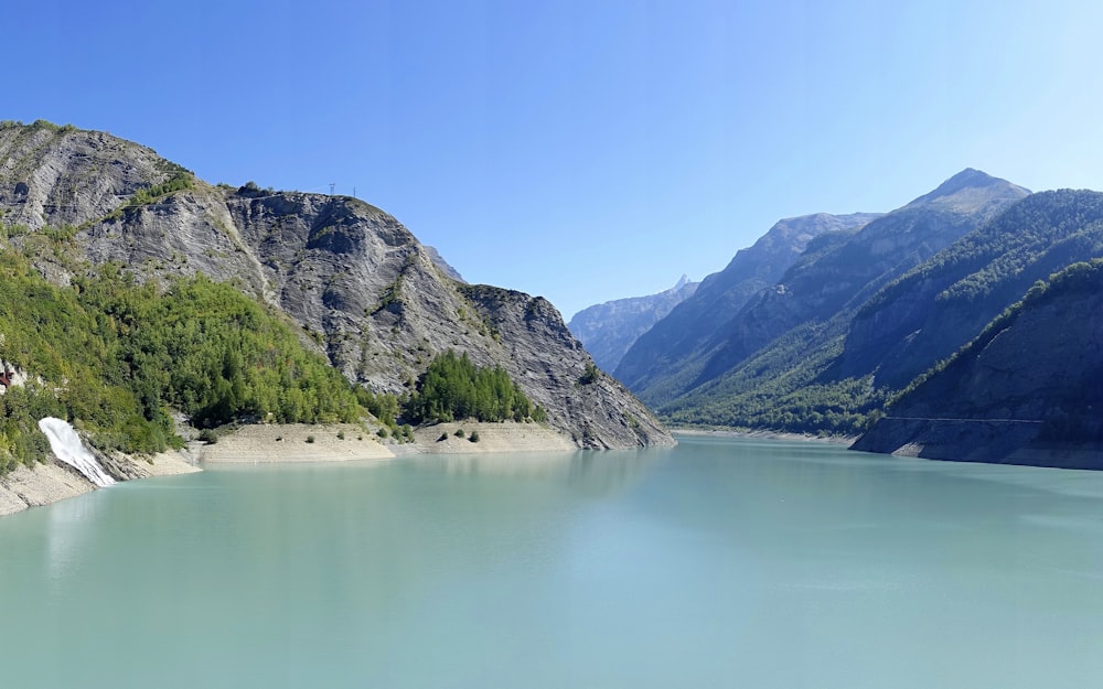 green body of water surrounded by green mountains