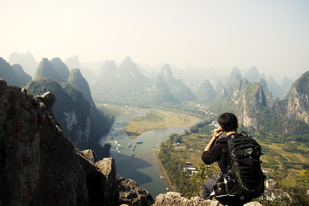 man sitting on mountain top during daytime