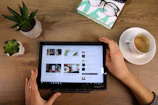 A person reading an AI news article on a sleek tablet in a cozy, minimalist room.