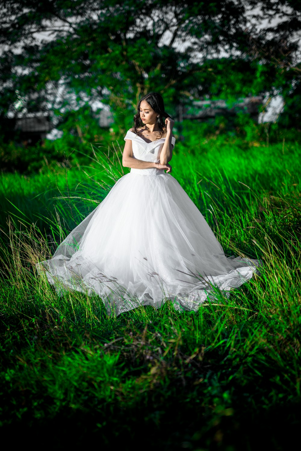 woman wearing wedding gown while standing on field of grass