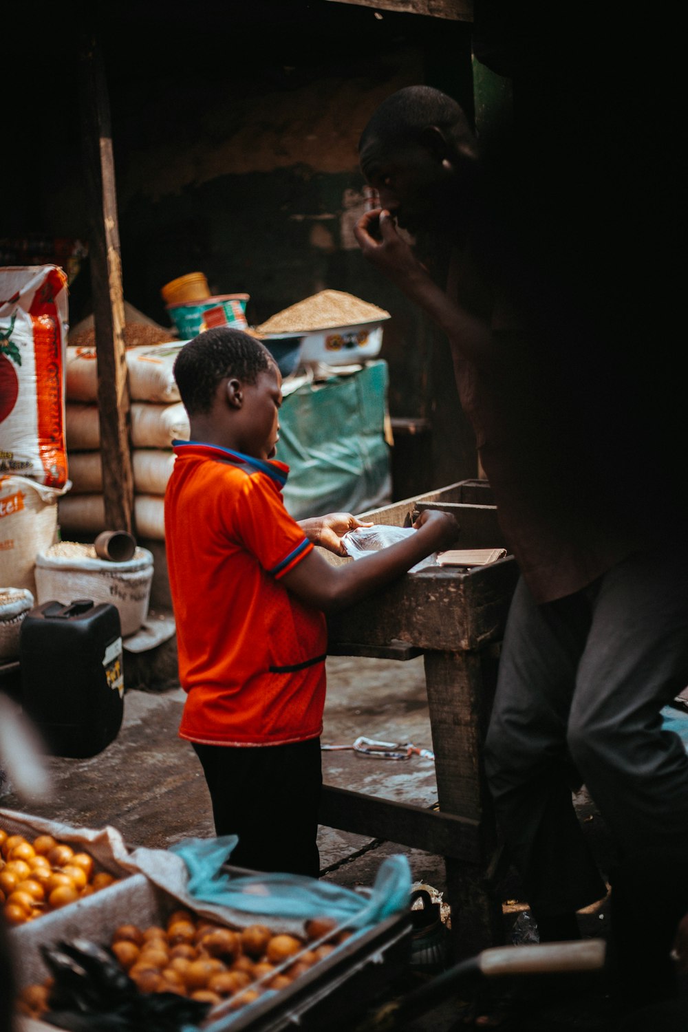 boy in red polo shirt standing on market during daytime