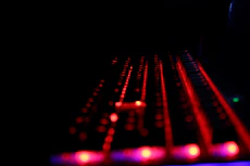 Keyboard keys illuminated with red and gold lighting in a dark setting.