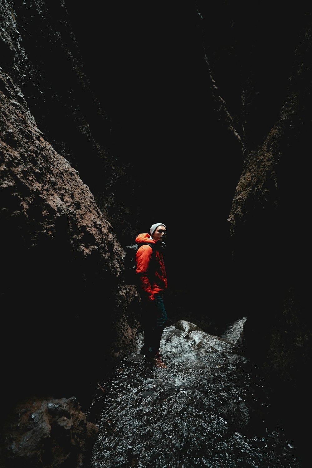 man standing between rock formation during daytime