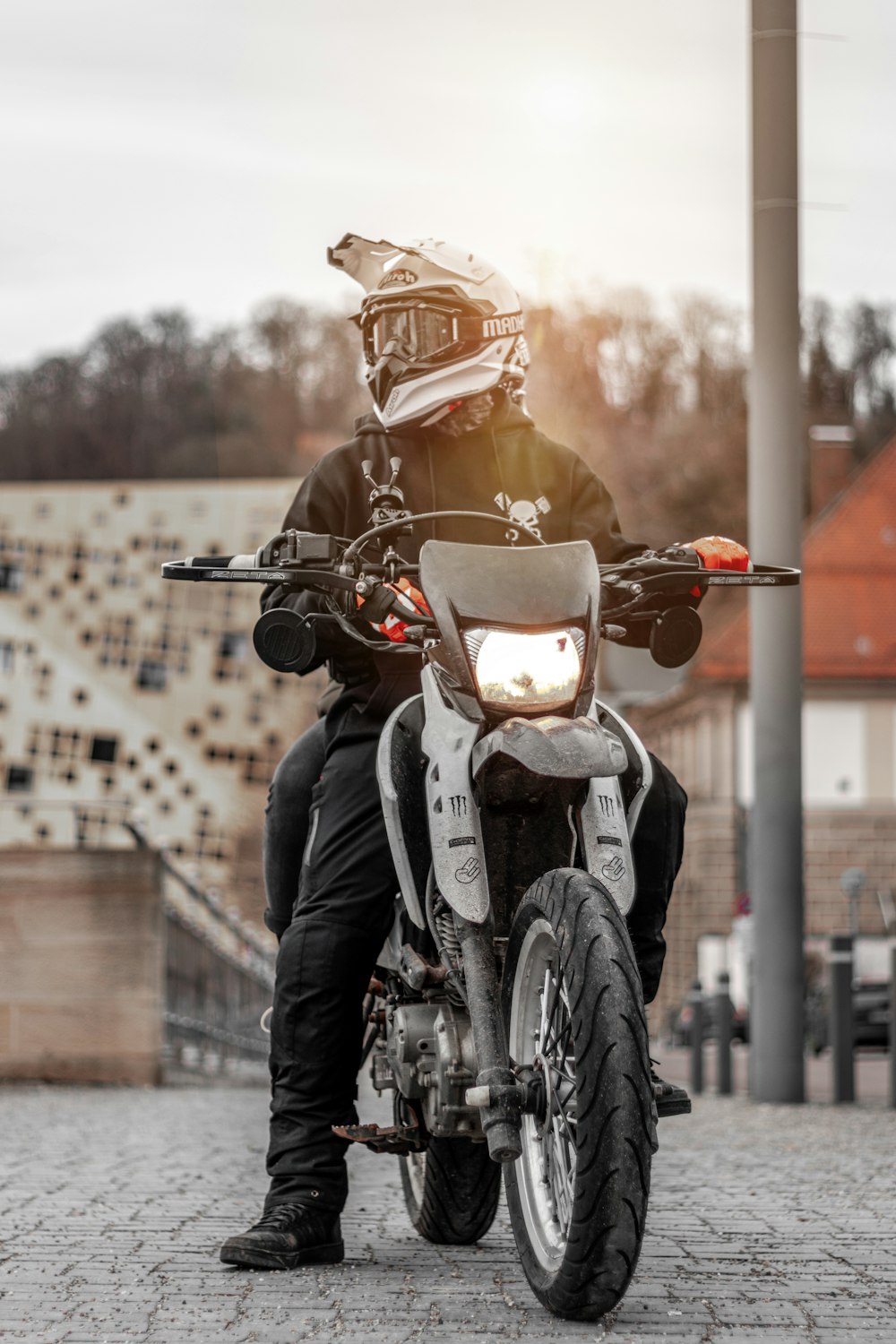 man riding motorcycle parking near pole