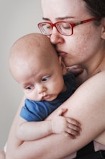close eyed woman carrying a baby