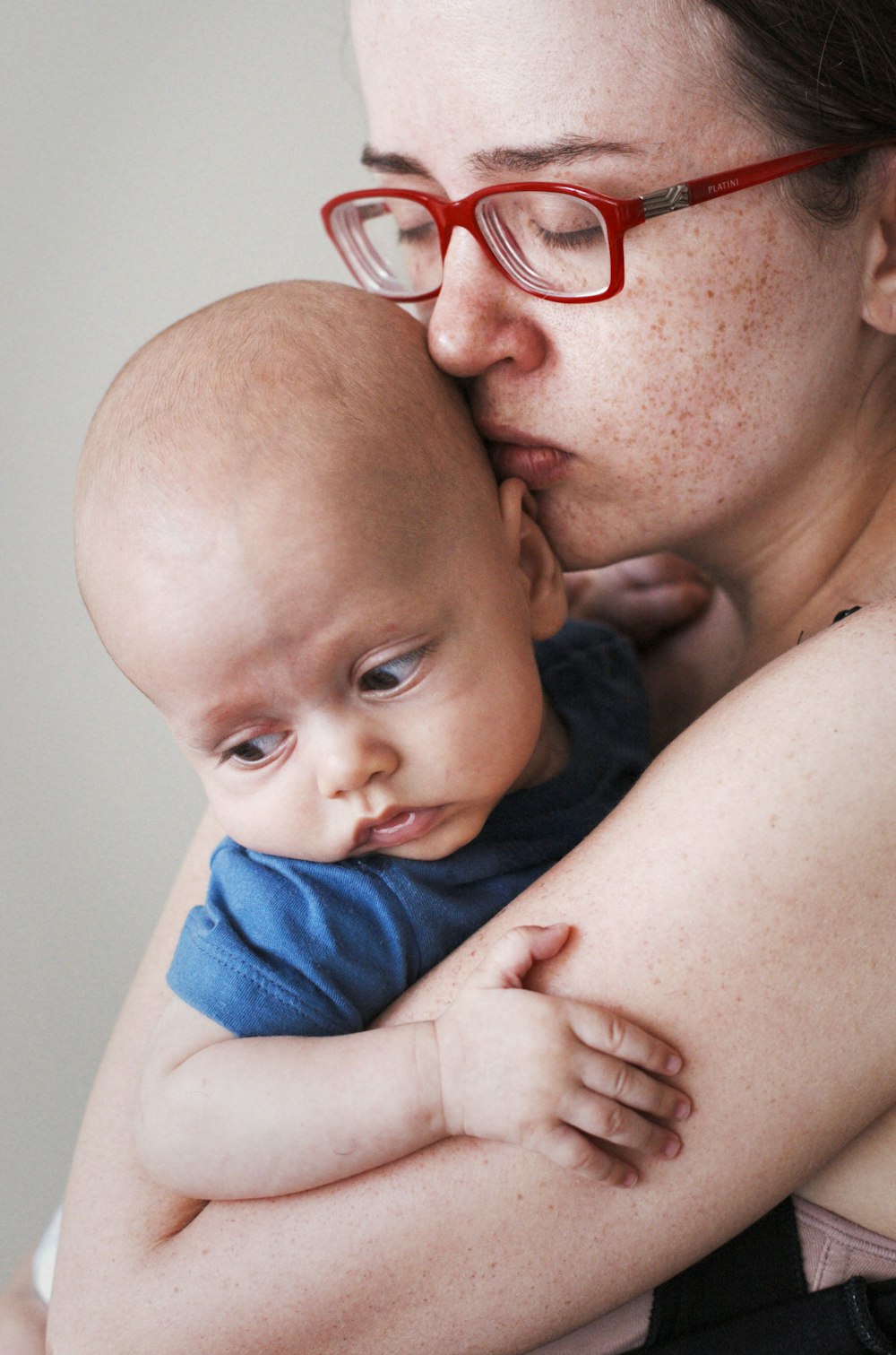 mulher de olhos fechados carregando um bebê