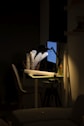 three paper rolls in basket on table with table lamp that is turned on