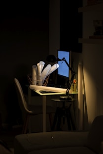 three paper rolls in basket on table with table lamp that is turned on