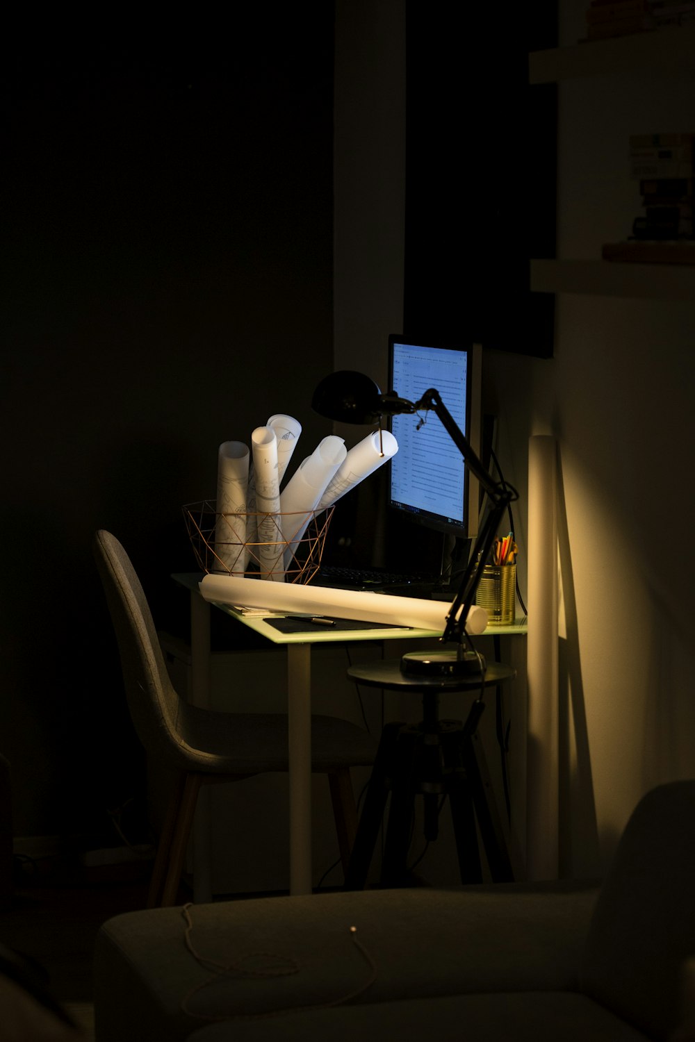 trois rouleaux de papier dans un panier sur une table avec une lampe de table allumée