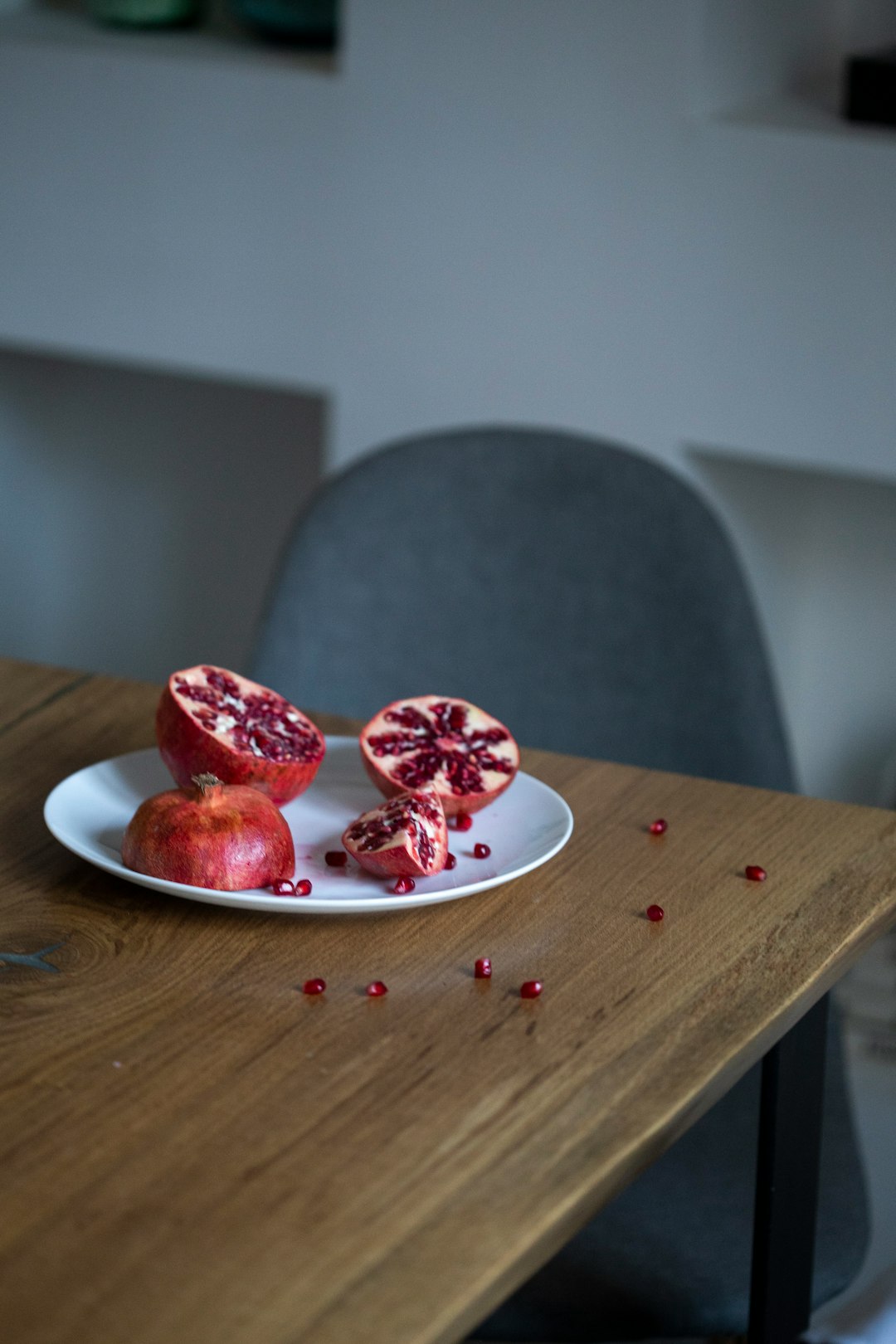 pomegranate fruit sliced into half on white plate