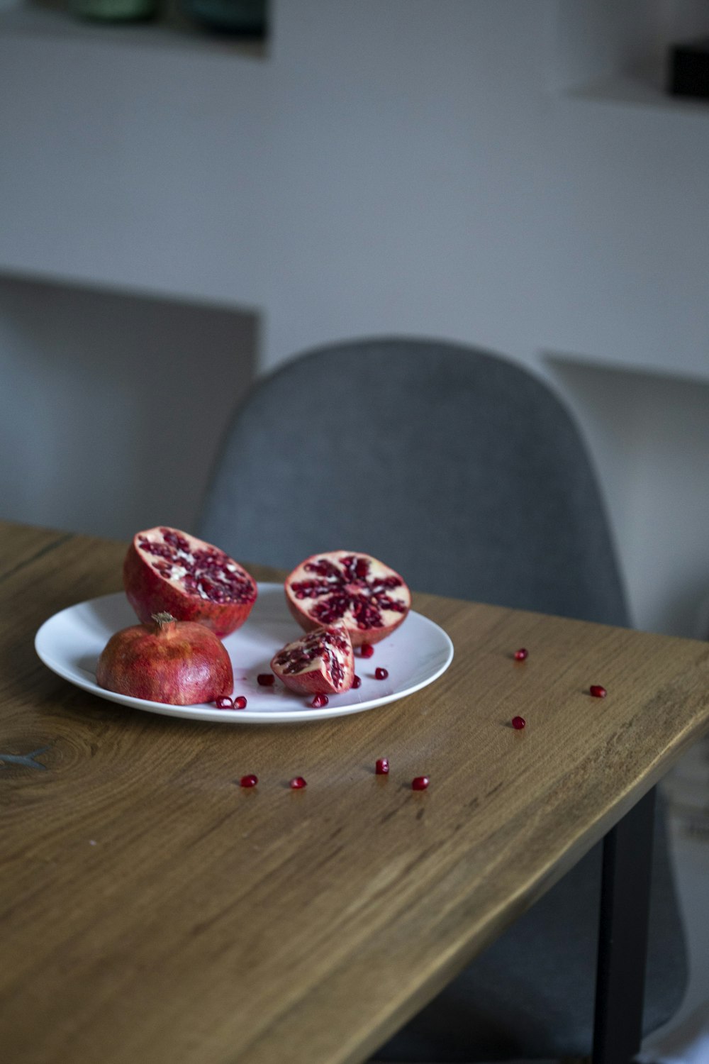 pomegranate fruit sliced into half on white plate