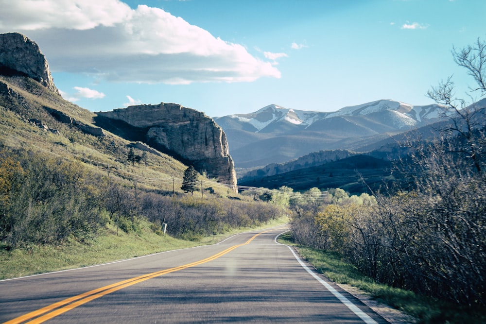 gray road with gray mountains ahead during daytime