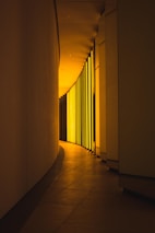 Softly lit hallway with textured wall finishes and ambient lighting creating depth.
