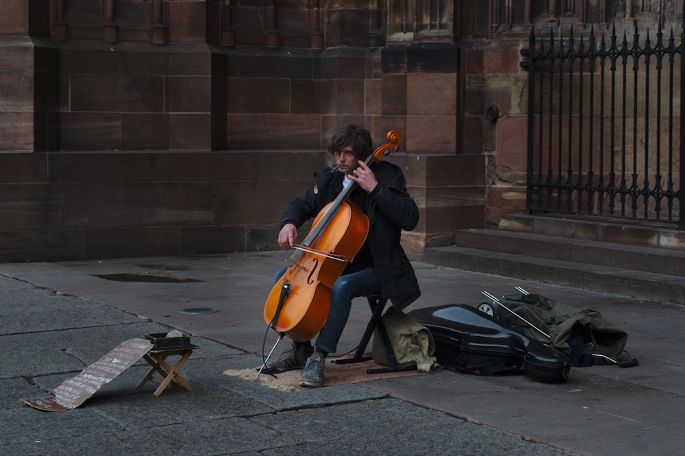 Hombre tocando el violonchelo cerca de Black Gate