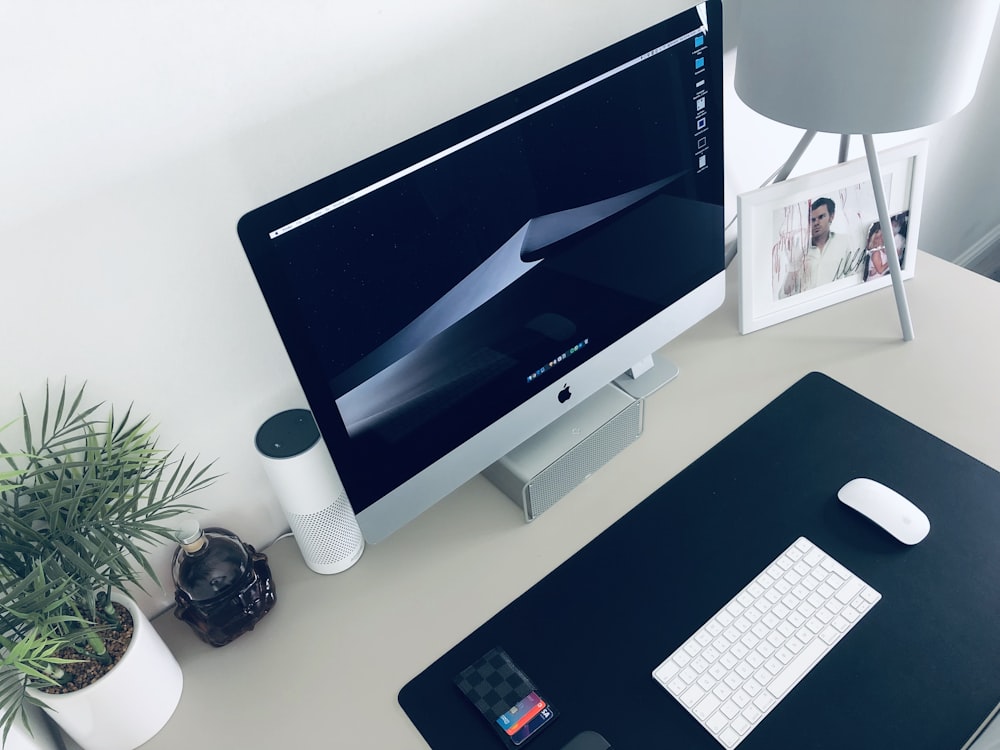 turned on silver iMac on white desk