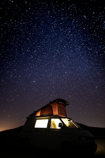 camper van under starry sky during nighttime