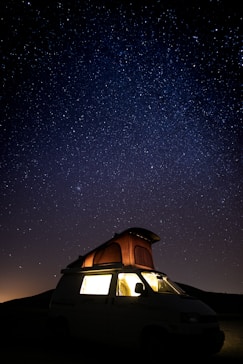camper van under starry sky during nighttime